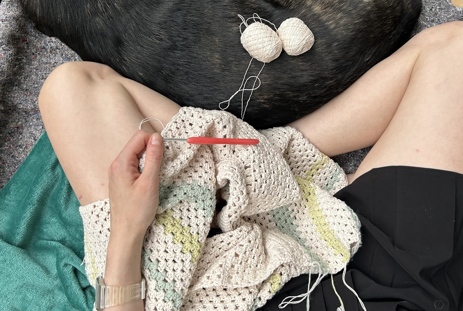 Hands crocheting a garment with dark yarn